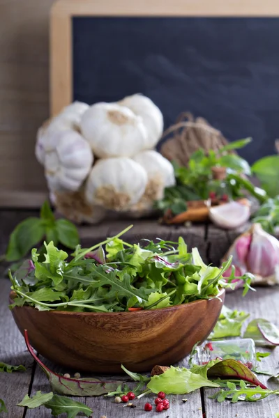 Salada verde deixa em uma tigela de madeira — Fotografia de Stock