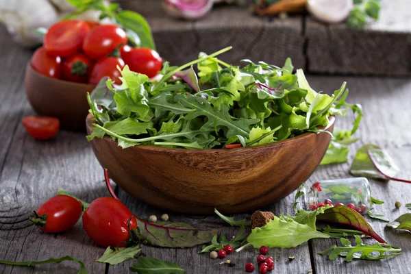 Salada verde deixa em uma tigela de madeira — Fotografia de Stock