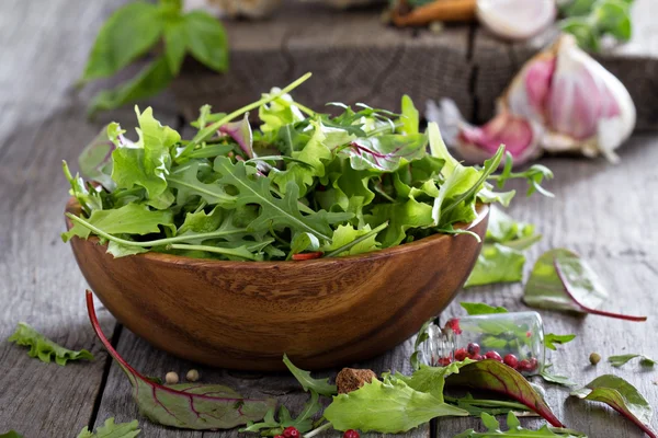 Green salad leaves in a wooden bowl — Stock Photo, Image