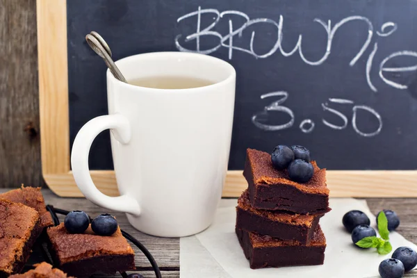 Brownies empilhados com uma xícara de chá — Fotografia de Stock