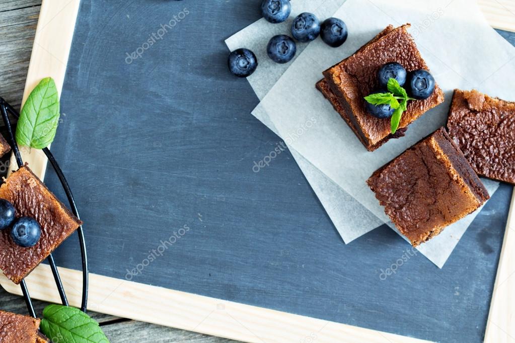 Brownies with blueberries on a chalkboard
