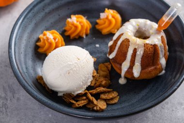 Rom katılmış balkabağı keki. Dondurma ile servis ediliyor.