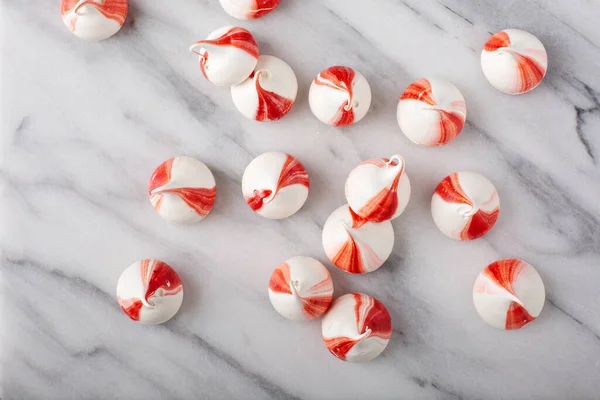 Peppermint meringues on a marble table, Christmas background — Stock Photo, Image