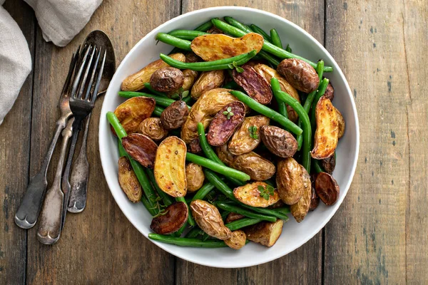 Patatas alevines crujientes asadas con judías verdes en un tazón de servir — Foto de Stock