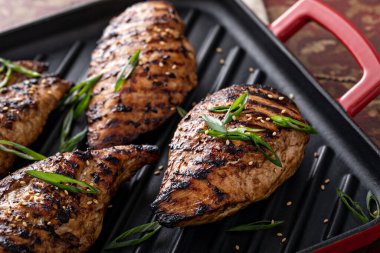 Izgara teriyaki tavuk göğsü ve yeşil soğanlı ızgara tava.