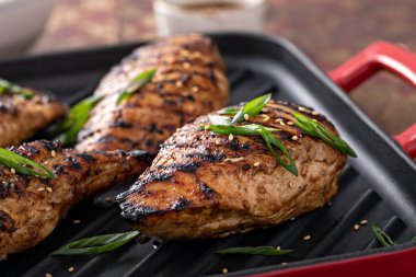 Izgara teriyaki tavuk göğsü ve yeşil soğanlı ızgara tava.