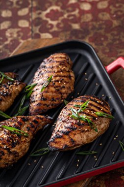 Izgara teriyaki tavuk göğsü ve yeşil soğanlı ızgara tava.