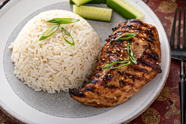 Grilled teriyaki chicken breast with rice and fresh cucumber