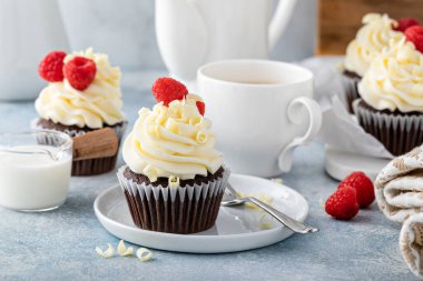 Çikolatalı kekler, beyaz çikolata kremalı ve ahududulu.