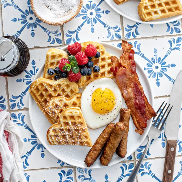 Mesa de desayuno con gofres. huevo frito, tocino y salchicha —  Fotos de Stock