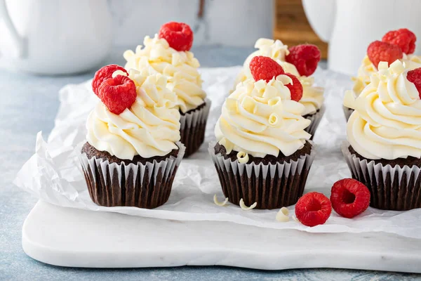 Bolinhos de chocolate com cobertura de chocolate branco e framboesas — Fotografia de Stock