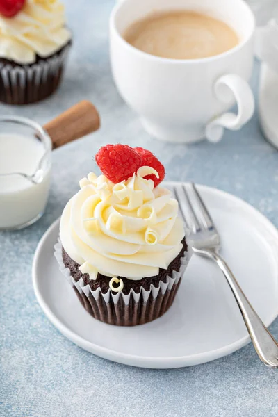 Cupcakes au chocolat avec glaçage au chocolat blanc et framboises — Photo