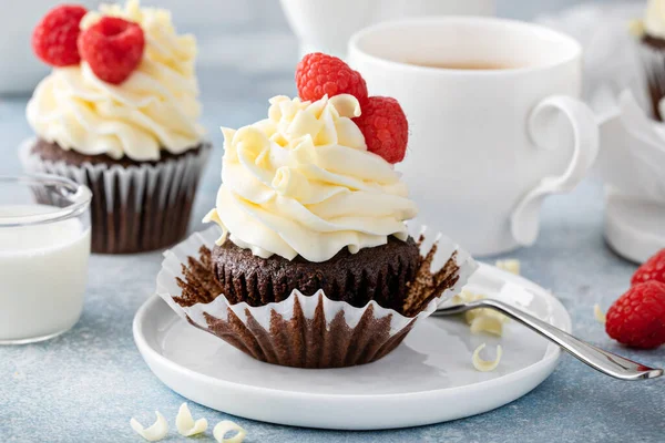 Cupcakes au chocolat avec glaçage au chocolat blanc et framboises — Photo