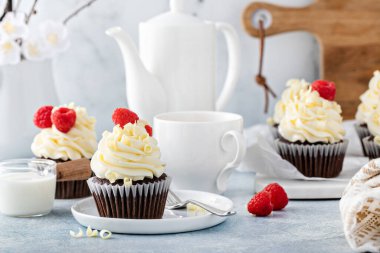 Çikolatalı kekler, beyaz çikolata kremalı ve ahududulu.