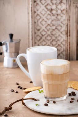 Bardakta ve kupada sıcak kahve ve kapuçino.