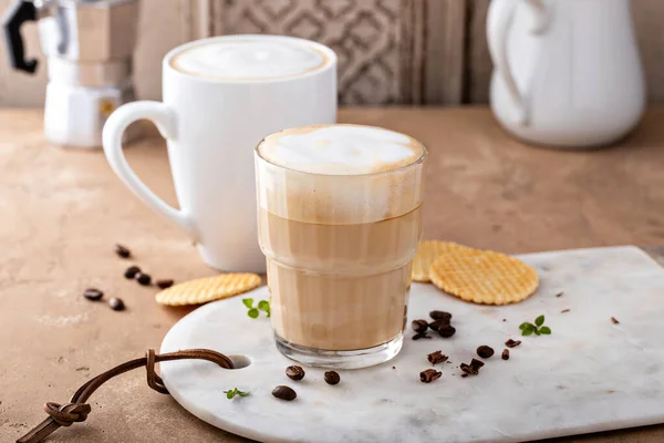 Café quente latte e cappuchino em um copo e caneca — Fotografia de Stock