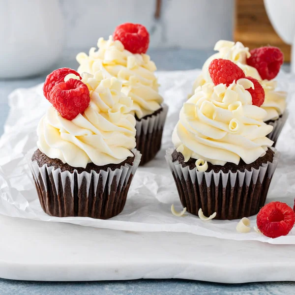 Bolinhos de chocolate com cobertura de chocolate branco e framboesas — Fotografia de Stock