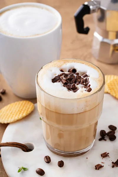 Varmt kaffe latte och cappuchino i ett glas och mugg — Stockfoto