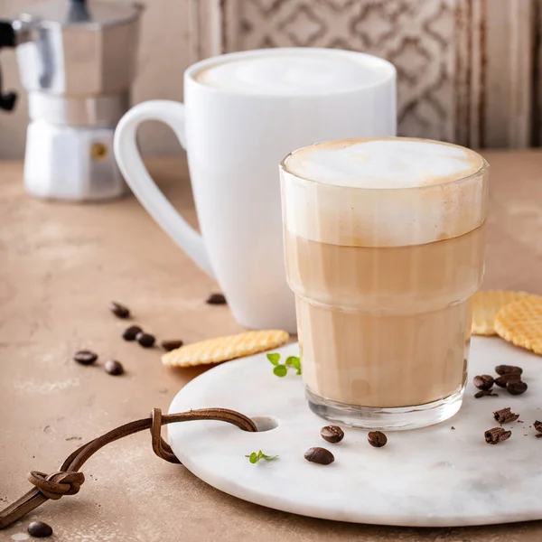 Varmt kaffe latte och cappuchino i ett glas och mugg — Stockfoto