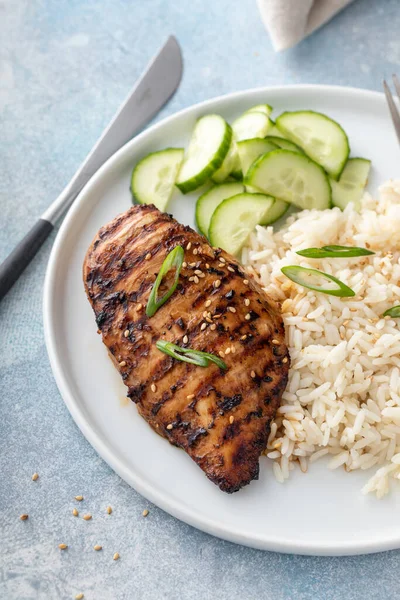 Grilled teriyaki chicken breast with rice and fresh cucumber