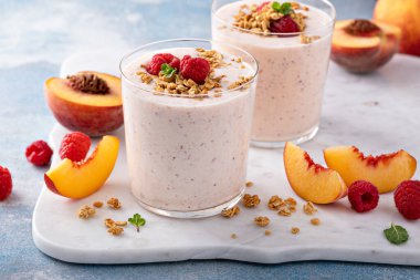 Granola ve böğürtlenli ahududu şeftalili smoothie, sağlıklı ve ferahlatıcı bir içecek.