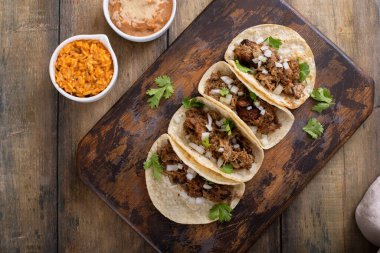 Meksika pilavı ve fasulyeli kişniş ve soğanlı domuz carnitas taco.