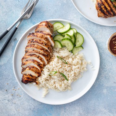 Kızarmış teriyaki bal zencefilli tavuk göğsü. Pirinç ve taze salatalık ile dilimlenmiş.