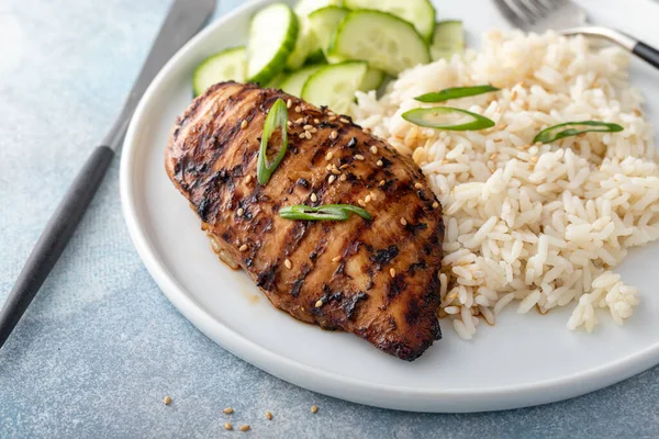 Grilled teriyaki honey ginger chicken breast with rice and fresh cucumber