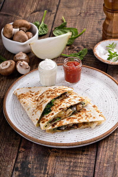 Quesadillas with mushroom, spinach and caramelized onions with sour cream and salsa