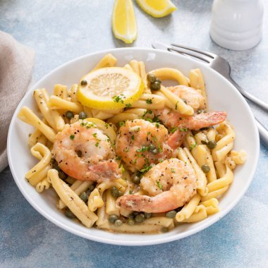Limonlu karides piccatta makarna, limon ve kapari ile servis edilir.