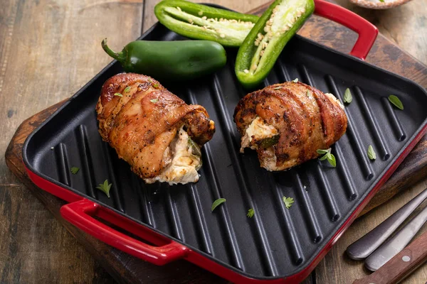 Jalapeno popper chicken breast wrapped with bacon on a grill pan