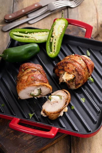 Jalapeno popper chicken breast wrapped with bacon on a grill pan