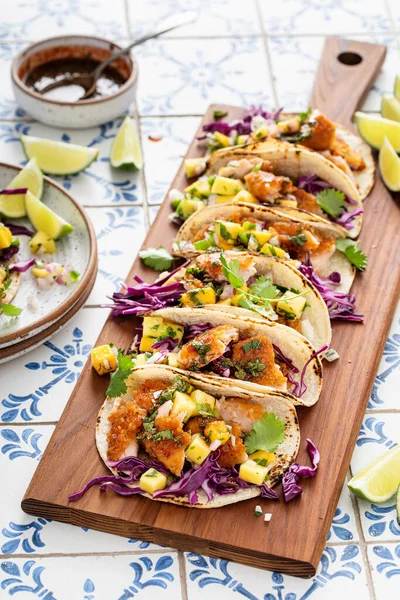 Fish tacos with mango salsa and red cabbage, salmon tacos board with beer and hot honey