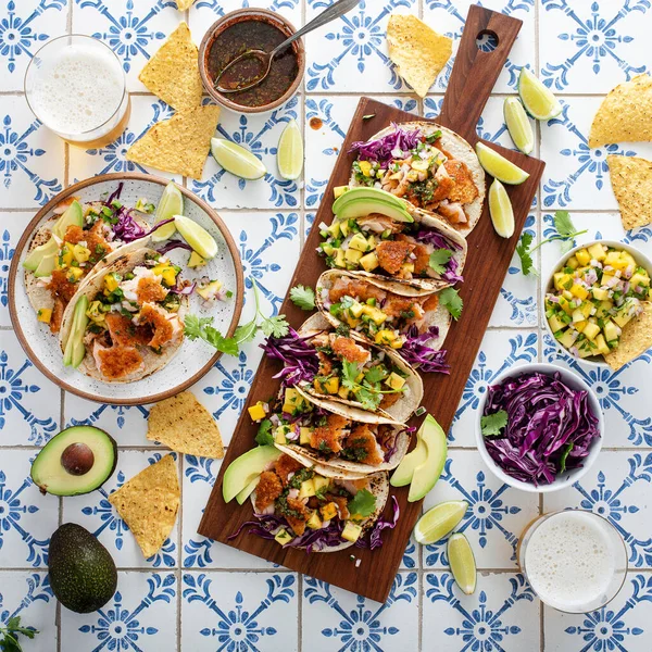 Fish tacos with mango salsa and red cabbage, salmon tacos board with beer and hot honey