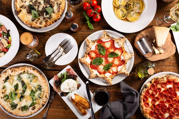 Variety of italian food on the table, pizza, pasta, cheese and appetizers