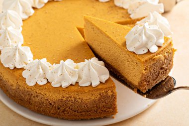 Sonbahar baharatlı balkabaklı cheesecake, krem şantili, Şükran Günü için tatlı, iki dilimli bütün pasta.