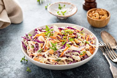 Asian cole slaw with creamy dressing, topped with salted roasted peanuts and green onion