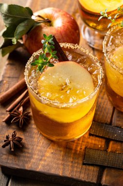 Apple cider margarita with brown sugar rim, cinnamon and fresh thyme, fall cocktail or mocktail idea in a rustic setting