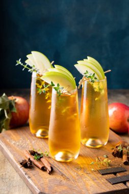 Apple cider mimosa for fall brunch, garnished with apple slices, autumn cocktail or mocktail idea