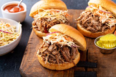 Pulled pork sandwiches with cole slaw and bbq sauce on brioche buns