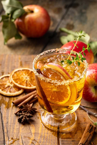 Festive fall cocktail or mocktail with hard cider, apple and orange with fall spices for Thanksgiving dinner