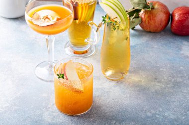 Variety of fall cocktails or mocktails made with apple cider in a light and bright setting, fall brunch drinks ideas
