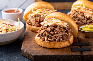 Pulled pork sandwiches with cole slaw and bbq sauce on brioche buns