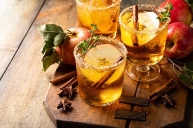 Apple cider margarita with brown sugar rim, cinnamon and fresh thyme, fall cocktail or mocktail idea in a rustic setting