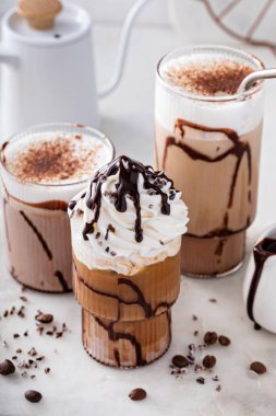 Mocha latte and iced frappe topped with whipped cream and chocolate syrup, refreshing and sweet coffee drinks