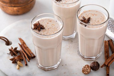 Chai freshly brewed indian spice tea in tall glasses with whole spices