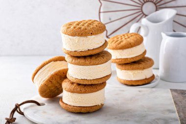 Vanilla ice cream sandwiches with peanut butter cookies stacked on the table