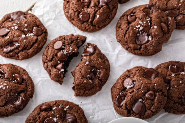 Double chocolate cookies with dark chocolate chips and salt flakes with a glass of milk