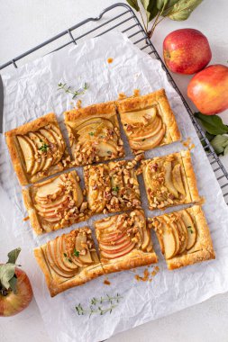 Apple tart with puff pastry tpped with sliced apples, walnuts and brown sugar caramel sliced into squares