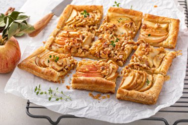 Apple tart with puff pastry tpped with sliced apples, walnuts and brown sugar caramel sliced into squares